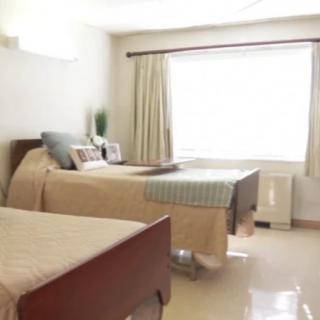 A bright and minimalist bedroom with two beds and a large window.