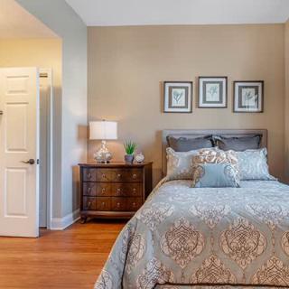 A cozy bedroom with a neatly made bed and elegant decor.