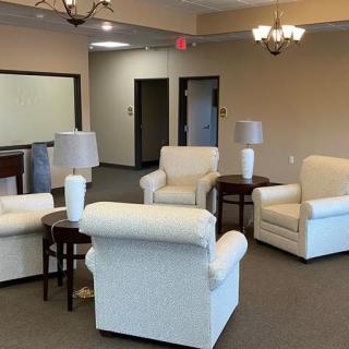 A cozy lobby seating area with armchairs and lamps.