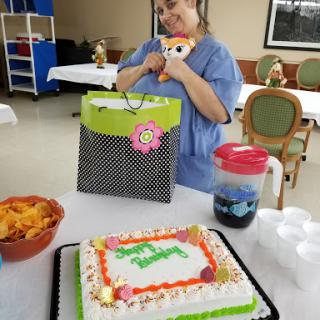 A joyful celebration featuring a decorated cake, gifts, and snacks.