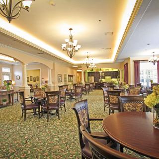 A spacious and elegantly furnished dining area with tables, chairs, and chandeliers.