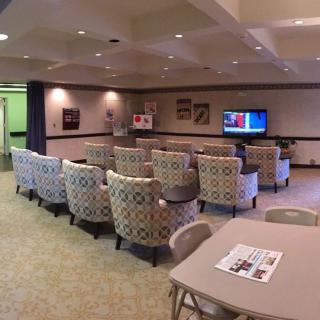 A small meeting area with rows of patterned chairs facing a television.