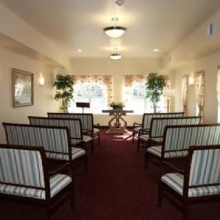 A small chapel with rows of striped seating and warm lighting.