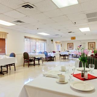 A spacious and elegantly arranged dining room setting, ready for guests.