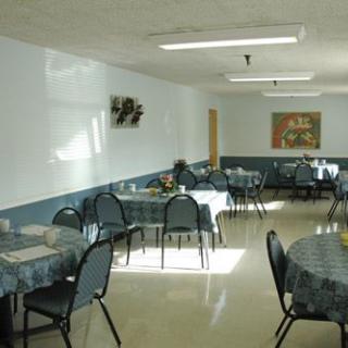 An empty cafeteria with neatly arranged tables and chairs in a well-lit interior.