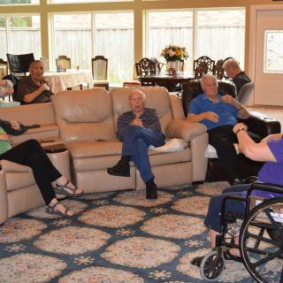 A group of seniors socializing in a comfortable living room setting.