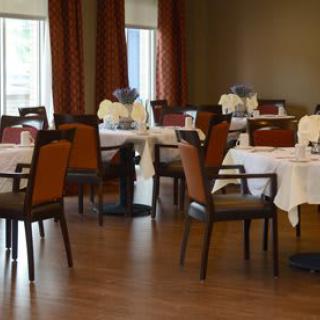 An elegant restaurant dining room with neatly set tables and chairs, ready for guests.