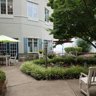 A serene outdoor patio area with seating and lush greenery.
