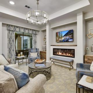 A modern living room with elegant decor, featuring a cozy fireplace and comfortable seating.