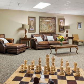 A cozy living room with leather sofas, elegant decor, and a chessboard on the table.