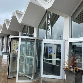 A modern building entrance featuring a revolving door and a sleek architectural design.