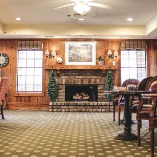 A cozy living room with a fireplace and wood-paneled walls.