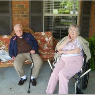 An elderly couple enjoying a peaceful moment on their porch.
