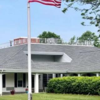 A house with an American flag on a flagpole in the front yard.