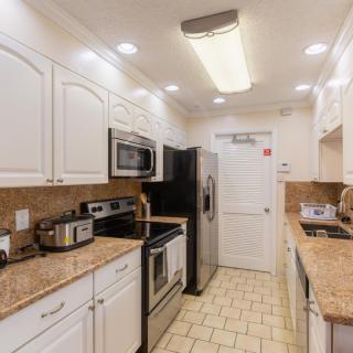 A modern kitchen with stainless steel appliances and white cabinetry.