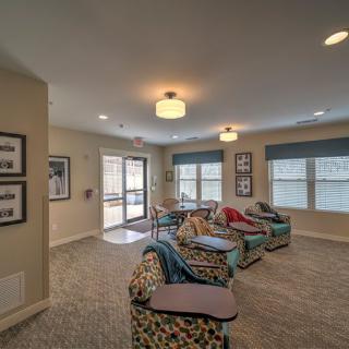 A cozy living room with colorful seating and large windows providing natural light.