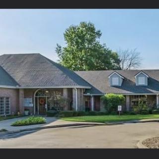 A suburban house with a wide driveway and well-maintained landscaping.