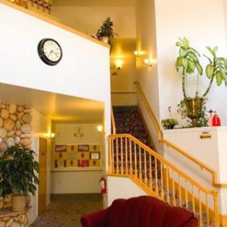 A cozy lobby interior with a staircase and decorative plants.