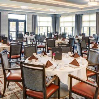 A banquet hall set up with round tables and chairs, ready for an event.