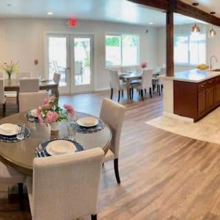 A spacious, modern open-plan dining and kitchen area with elegant decor and ample natural light.