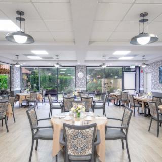 A well-lit restaurant dining area with neatly arranged tables and chairs.
