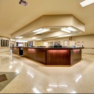 A spacious reception area with a central desk and bright lighting.