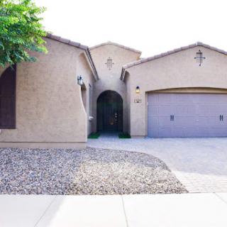 A charming residential home featuring a spacious garage and landscaped front yard.