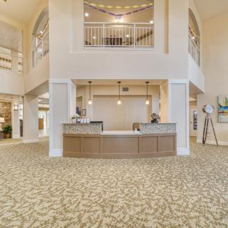 A spacious and elegantly designed hotel lobby with a central reception desk, modern lighting, and stylish decor.