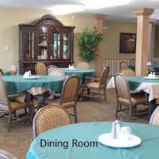 A well-arranged dining room with multiple tables covered in teal tablecloths.