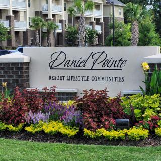 Entrance sign of an apartment complex with well-maintained landscaping.