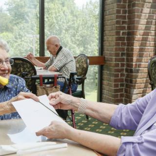 A group of seniors engaging in a lively discussion at a community center.