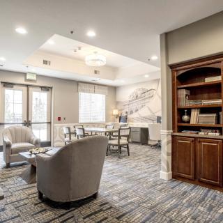 A modern lobby with comfortable seating and a bookshelf.