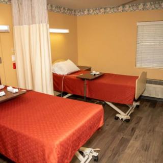 Hospital room with two beds separated by a curtain.