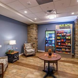 A cozy lounge area featuring comfortable seating and a snack bar with a beverage fridge.