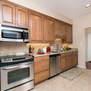 A modern kitchen with wooden cabinets and stainless steel appliances.
