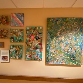 A collection of colorful abstract paintings displayed on a wall.