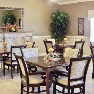 A cozy dining area with elegant furniture and decorative plants.