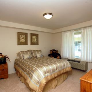 Cozy bedroom with a plaid bedspread and natural light.