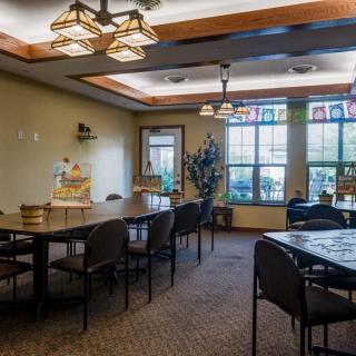 A bright and well-decorated meeting room with tables, chairs, and large windows.
