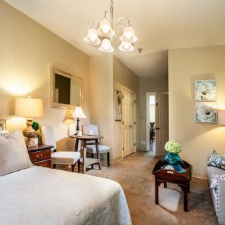 A cozy bedroom with elegant lighting and classic furniture arrangement.