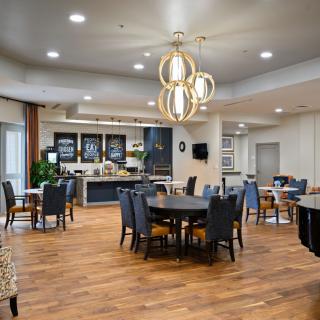 A modern dining area with elegant lighting and wooden flooring.