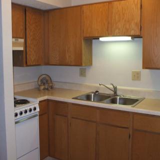 A cozy kitchen with wooden cabinets and a double sink.
