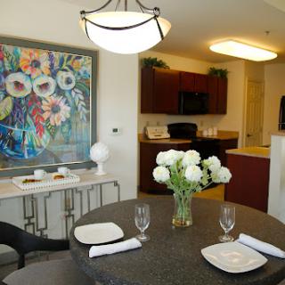 A stylish and inviting dining room featuring a modern table setting, floral centerpiece, and vibrant artwork.