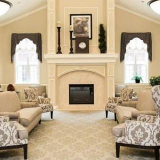 A classic and elegant living room with a central fireplace, surrounded by comfortable seating and tasteful decor.