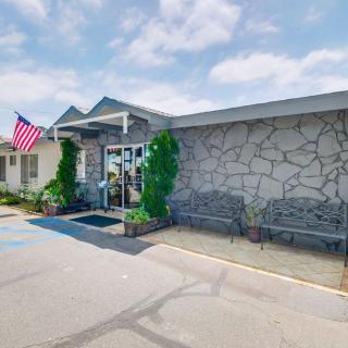 A building entrance with a stone facade, adorned by an American flag and flanked by benches.