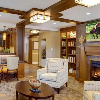 A modern living room with a fireplace, comfortable seating, and wooden accents.