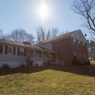 A suburban house with a brick exterior on a sunny day.