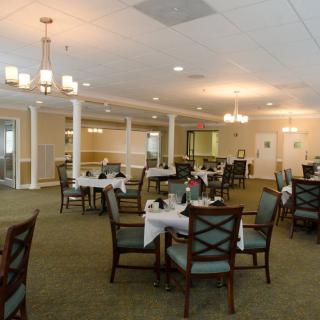 A spacious dining area with elegantly set tables and comfortable seating.