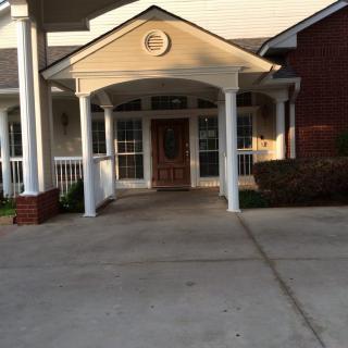 A residential building entrance with a porch supported by columns.