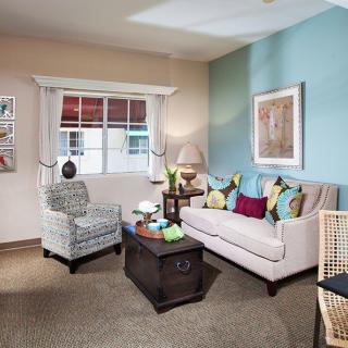 A cozy living room featuring a sofa, armchair, and coffee table with decorative accents.